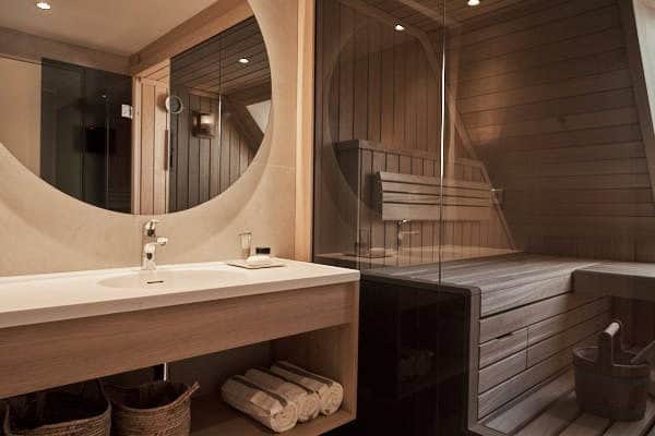 Solid surface wastafel met geïntegreerde kom op een houten meubel in een wellnessruimte met sauna, Hof van Saksen